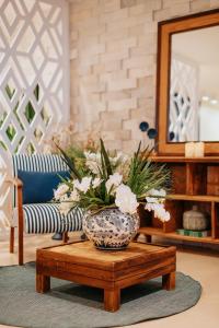 a vase with flowers on a table in a living room at Casa Cancun Eventos e Hotel Boutique in Penha