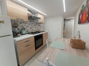een keuken met houten kasten en een witte koelkast bij Bilocale in centro storico -Le mensaline- Casa Chiricopo in Modica