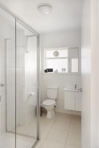 uma casa de banho com um WC e uma cabina de duche em vidro. em MAC South Yarra by Melbourne Apartment Collection em Melbourne