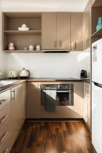 uma cozinha com electrodomésticos em aço inoxidável e pisos em madeira em MAC South Yarra by Melbourne Apartment Collection em Melbourne