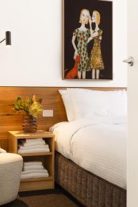 a bedroom with a bed and a picture of two women at MAC South Yarra by Melbourne Apartment Collection in Melbourne