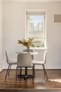 uma mesa de jantar com cadeiras e uma janela em MAC South Yarra by Melbourne Apartment Collection em Melbourne