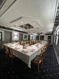 a dining room with a long table and chairs at Hotel 9-enhof in Wuppertal
