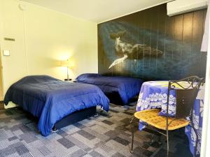 1 dormitorio con 2 camas y una pintura de un ciervo en Arnott's Lodge & Hiking Adventures en Hilo