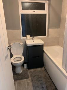 a bathroom with a toilet and a sink and a tub at stranmillis Suites in Belfast