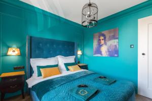 een blauwe slaapkamer met een bed met een blauwe muur bij Royal Łazienki Park by Better Place in Warschau