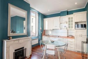 eine Küche mit einem Glastisch und einem Kamin in der Unterkunft Cannes Luxury Rental - Cosy apartment to rent 50m from the beaches in Cannes
