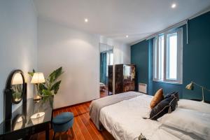 Schlafzimmer mit blauen Wänden und einem Bett mit Spiegel in der Unterkunft Cannes Luxury Rental - Cosy apartment to rent 50m from the beaches in Cannes