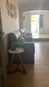 sala de estar con sofá azul y mesa en Casa na Praia Maragogi, en Maragogi