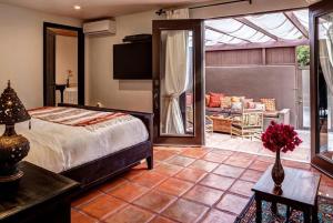 Talavera Palm Springs في بالم سبرينغز: غرفة نوم مع سرير وغرفة معيشة