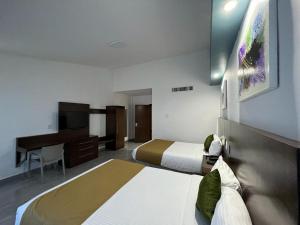 ein Hotelzimmer mit 2 Betten und einem Schreibtisch in der Unterkunft Solamar Inn Mazatlan in Mazatlán