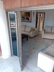ein Wohnzimmer mit Glasschiebetüren und einem Sofa in der Unterkunft Hermoso in Neiva