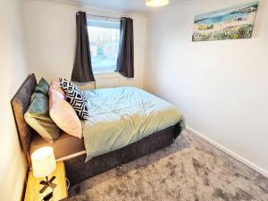 a small bedroom with a bed and a window at Whitefield, Manchester in Manchester