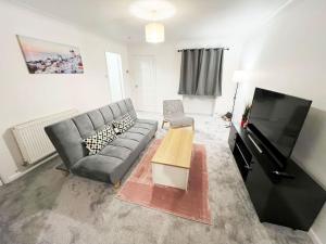 a living room with a couch and a flat screen tv at Whitefield, Manchester in Manchester