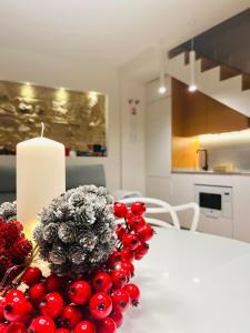 einen weißen Tisch mit einer Kerze und roten Beeren drauf in der Unterkunft Casa Torre Hacho in Antequera