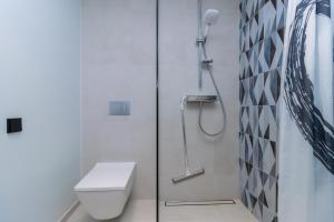 a white bathroom with a shower and a toilet at Cozy apartment by the Baltic Sea in Tallinn