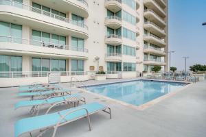 a swimming pool in front of a building at Resort-Style Biloxi Condo Walk to the Beach! in Biloxi