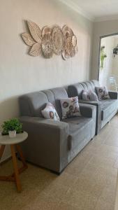 un sofá gris en una sala de estar con mesa en Casa na Praia Maragogi, en Maragogi
