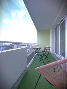 a balcony with a hammock and a table and chairs at Le Sunset-Cosy appart avec parking et balcon in Le Havre