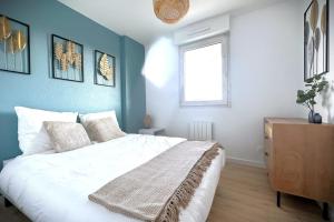 a bedroom with a white bed and a window at Le Sunset-Cosy appart avec parking et balcon in Le Havre