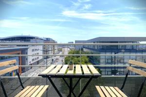 a balcony with two benches and a view of a city at Le Sunset-Cosy appart avec parking et balcon in Le Havre