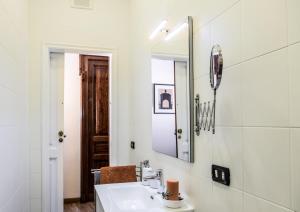 a white bathroom with a sink and a mirror at Casa Frangiò Modern Apartment Historical Centre in Naples