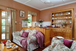 ein Wohnzimmer mit Sofa und Tisch in der Unterkunft Amanda's Cottage 1899 in McLaren Vale + 7 Fotos
