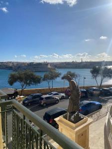 eine Statue vor einem Parkplatz mit Autos in der Unterkunft Grand Harbour View in Valletta