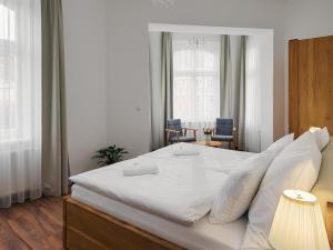 sypialnia z dużym białym łóżkiem z białymi poduszkami w obiekcie IMPERIAL Apartments w Karlowych Warach