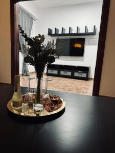 un tavolo con vassoio con vaso di fiori e bicchieri di Avenida 52 A a Los Llanos de Aridane