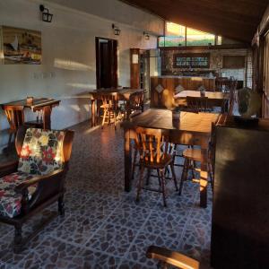 a dining room with wooden tables and chairs at Pousada dos Quiosques in Viamão