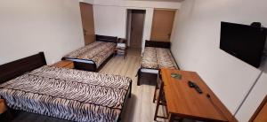 a room with three beds and a flat screen tv at Sen na Roztoczu in Szczebrzeszyn