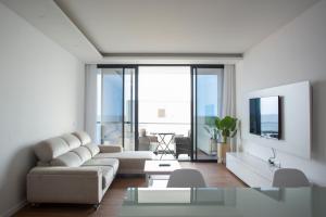 - un salon avec un canapé et une table dans l'établissement 3 bdr aprt, rooftop pool & seaview - LCGR, à Praia