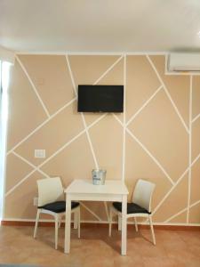 巴勒摩的住宿－Sofia Apartment，一张带两把椅子的白色桌子和墙上的电视