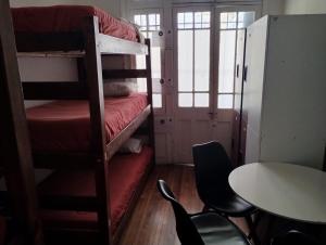 a room with two bunk beds and a table and chairs at Wild Bellavista Hostel in Santiago