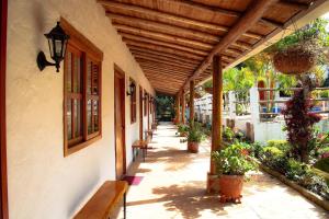 洛斯桑托斯的住宿－Hotel Boutique Santa Clara Mesa de los Santos，楼内有长椅和植物的门廊