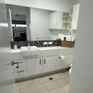 a white bathroom with two sinks and a mirror at New Farm 2 Bed 2 Bath 1 Car space perfect location in Brisbane