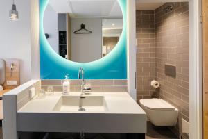 uma casa de banho com um lavatório e um espelho em Holiday Inn Express Dresden Zentrum, an IHG Hotel em Dresden