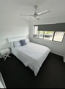 a white bedroom with a bed and a window at New Farm 2 Bed 2 Bath 1 Car space perfect location in Brisbane