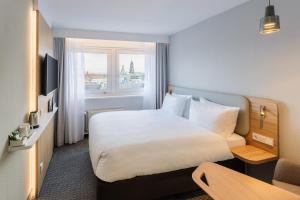 um quarto de hotel com uma cama e uma janela em Holiday Inn Express Dresden Zentrum, an IHG Hotel em Dresden