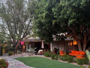 a yard with orange chairs and a house at Talavera Palm Springs in Palm Springs