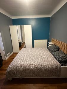 a bedroom with a bed and a blue wall at Appartement meublé à Croissy sur Seine in Croissy-sur-Seine
