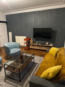 a living room with a couch and a tv at Appartement meublé à Croissy sur Seine in Croissy-sur-Seine