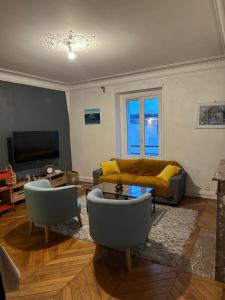 a living room with a couch and a table at Appartement meublé à Croissy sur Seine in Croissy-sur-Seine