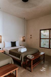- une chambre avec un lit et une table basse dans l'établissement Casona los Cedros, à Espita