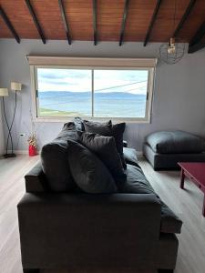 a couch in a living room with a large window at Casa del Valle in Ushuaia