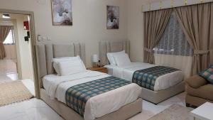 a hotel room with two beds and a couch at ليالي العروبة شقة مفروشة in Riyadh