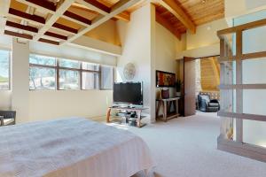 a bedroom with a bed and a flat screen tv at Gustafson Vineyard Retreat in Geyserville