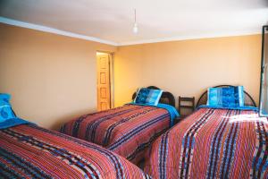 twee bedden naast elkaar in een kamer bij Ima Sumaj Hostel in Copacabana