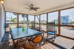 a screened porch with a table and chairs at Livin Is Easy in Edisto Island